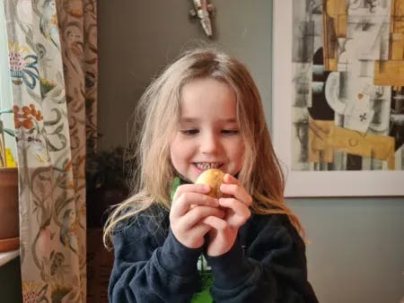 Jente (3 år) smiler med egget. Fotografi